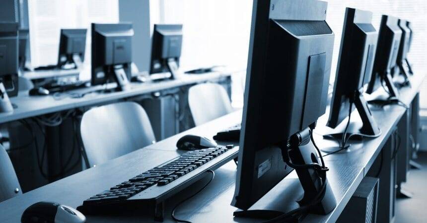 Desktop computer hardware and a monitor set up on a workbench for testing