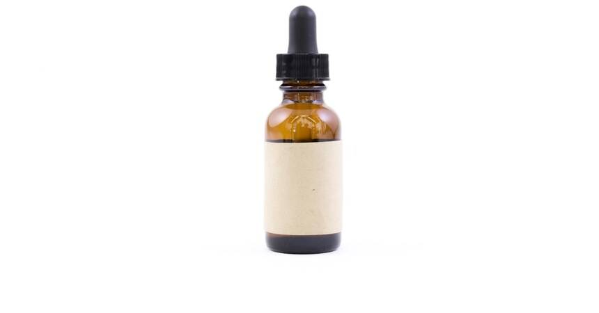 Amber cosmetic dropper bottle with a blank label ready for the mandatory information
