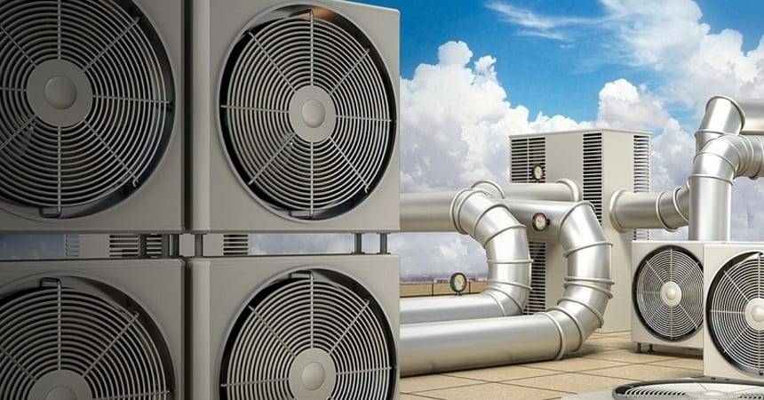 Rooftop air conditioning condenser units and ventilation ductwork against a blue sky