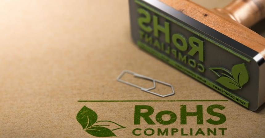 Rubber stamp reading RoHS Compliant beside its green printed impression on brown paper