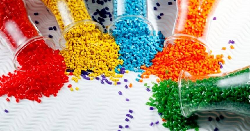 Coloured plastic granules spilling from glass tubes onto a white surface