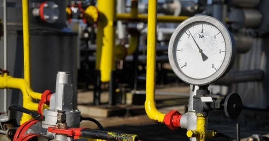 Yellow gas pipework with red valves and a large white pressure gauge at a distribution station