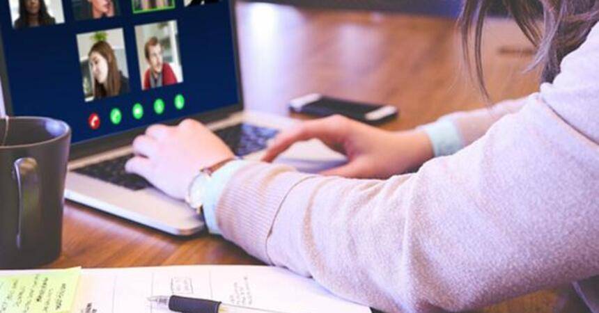 Person at a laptop in a video conference with several participants on screen